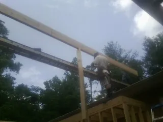 Carpenter setting a ridge beam over a new addition frame — Ice Dam Removal by Roofing Brothers in Hackettstown