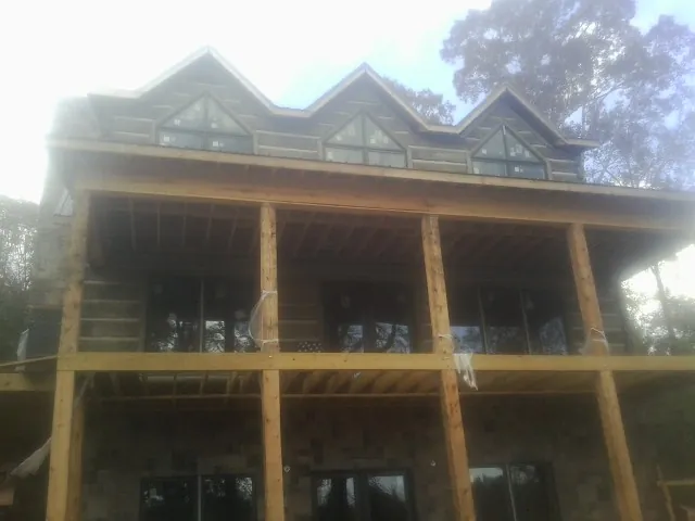 Dormers and porch framing on a large log home under construction — Roof Coating work by our crew in Hackettstown