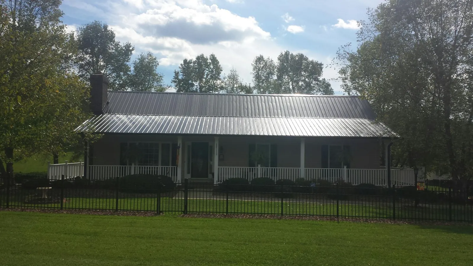 Gray metal roof on a brick ranch with a full width front porch — Gutter Guard Installation work by our crew in Hackettstown