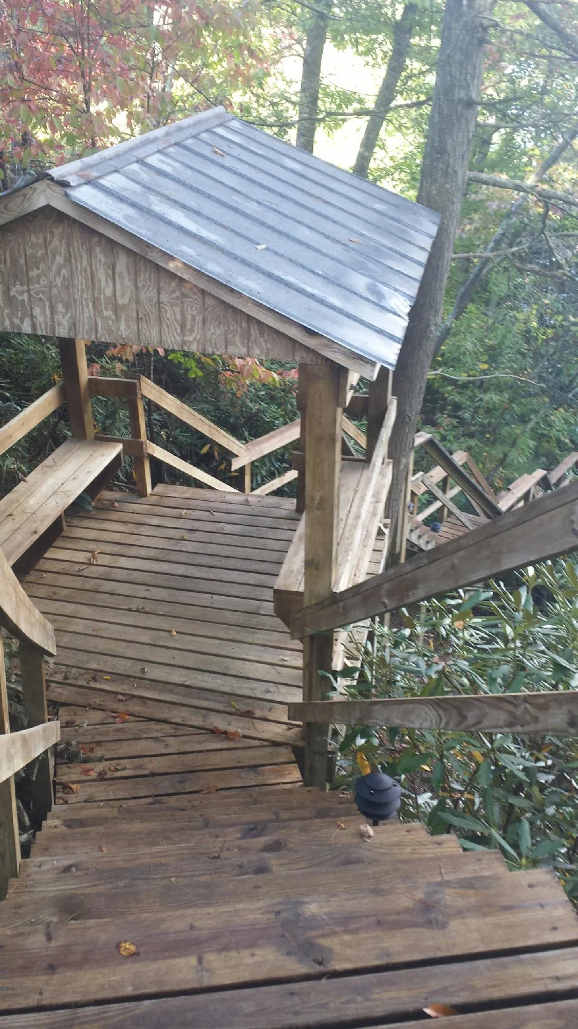 Metal roofed shelter over wooden steps on a wooded walkway — Skylight Repair & Installation work by our crew in Hackettstown